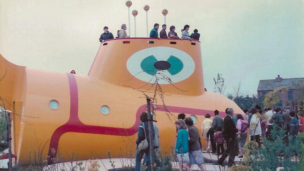 The replica of The Beatles Yellow Submarine from the eponymous movie with people on board it at the festival site in 1984.