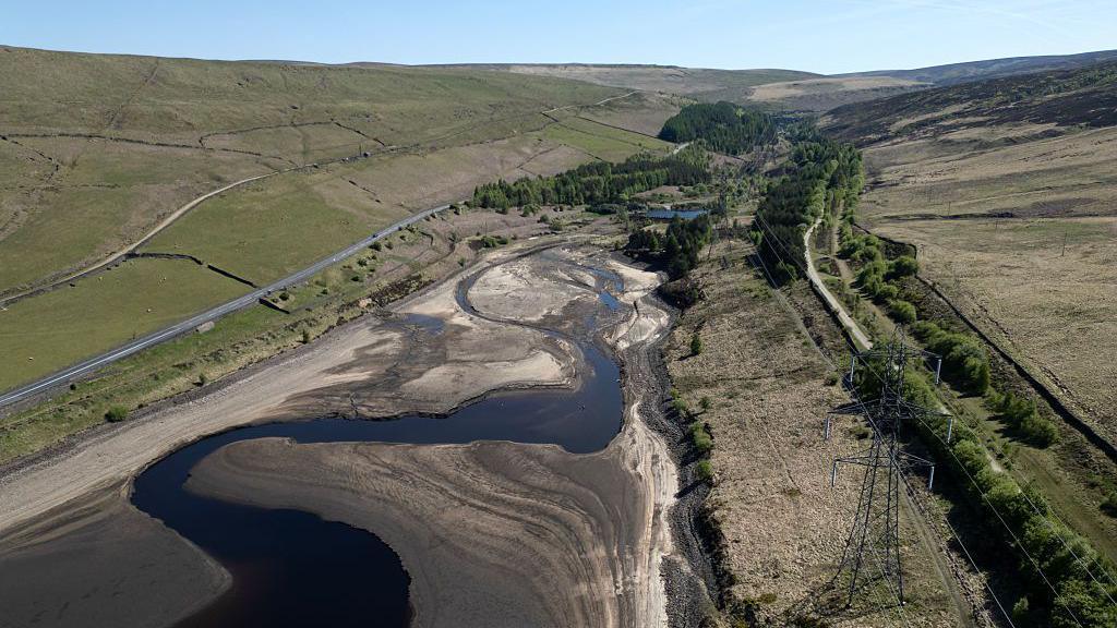 An aerial photo shows the bed of Woodhead Reservoir is partially revealed by a falling water level