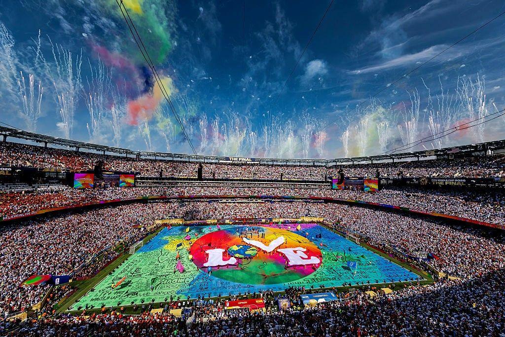 A wide shot of the stadium with a colourful stage in the centre and the word "love" written in the middle