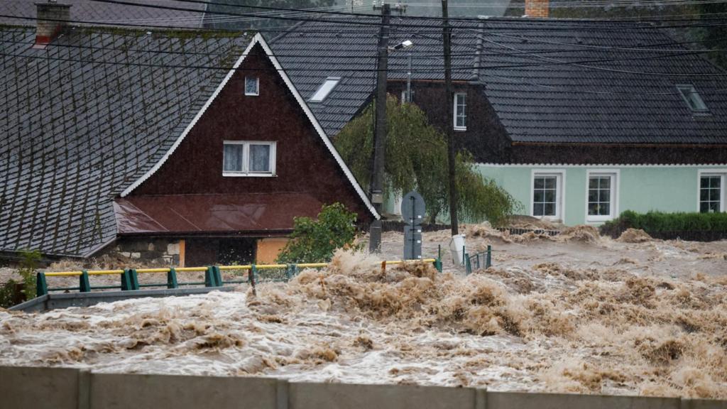  Flood water rushing past houses in Lipova Lazne, Czech Republic