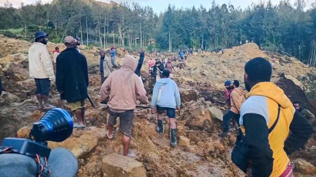 People gather at the site of a landslide in Maip Mulitaka in Papua New Guinea's Enga Province