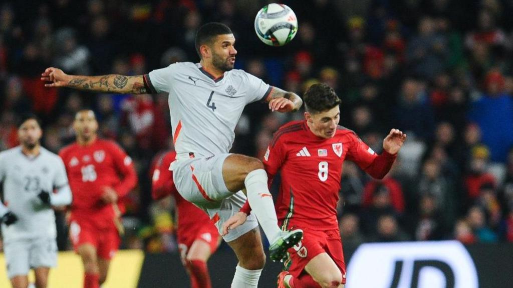 Victor Palsson challenges Wales forward Harry Wilson