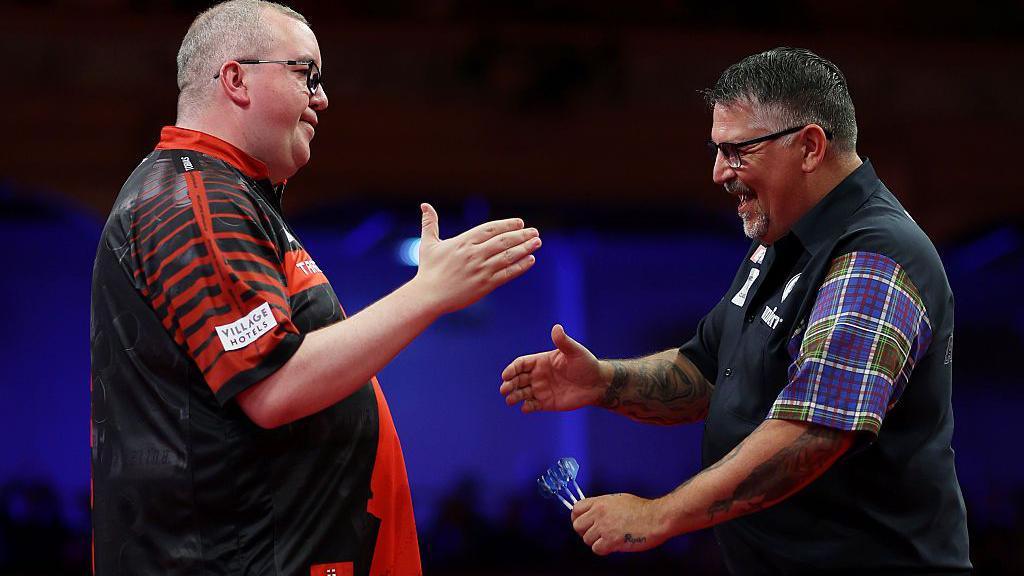 Stephen Bunting shaking hands pinch Gary Anderson astatine nan extremity of nan game.