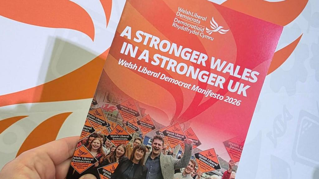 The Welsh Liberal Democrats manifesto. It is an orange and red booklet.