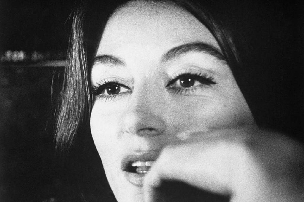 Anouk Aimée rests her chin on her hand as Anne Gauthier in the 1966 French film A Man and a Woman