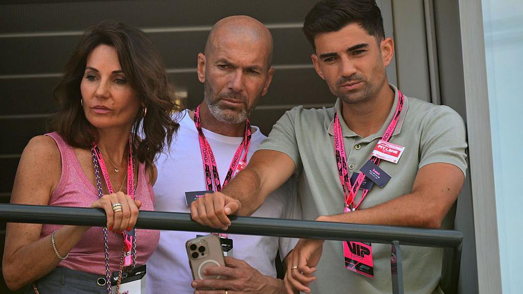 World Cup and Ballon d'Or winner Zinedine Zidane watches qualifying alongside his wife and son.