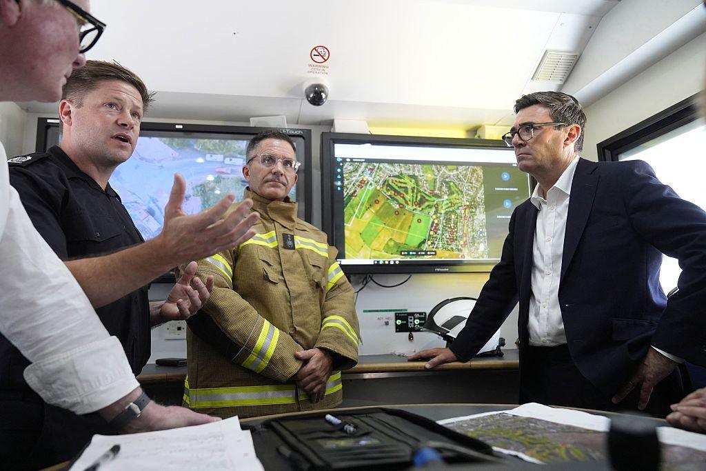 Prime Minister Andy Burnham speak with emergency responders at the West Midlands Fire Service incident command unit.