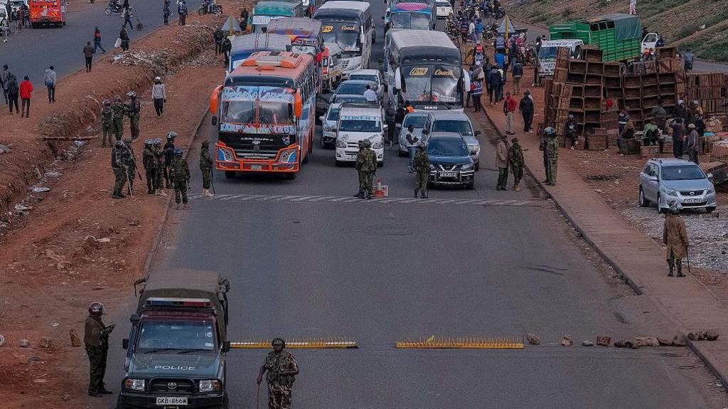 Police officers man a roadblock with buses and and other vehicles stopped from entering Nairobi central business 