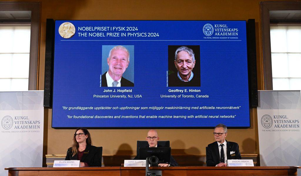 A screen shows the laureates of the 2024 Nobel Prize in Physics, US physicist John J Hopfield (top L) and Canadian-British computer scientist and cognitive psychologist Geoffrey E Hinton as (bottom LtoR) Chair of the Nobel Committee for Physics Ellen Moons, Secretary General of the Royal Swedish Academy of Sciences Hans Ellegren and Member of the Nobel Committee for Physics Anders Irbaeck make the announcement at the Royal Swedish Academy of Sciences in Stockholm, Sweden on October 8, 2024. American John Hopfield and British-Canadian Geoffrey Hinton won the Nobel Prize in Physics on October 8, 2024 for pioneering work in the development of artificial intelligence