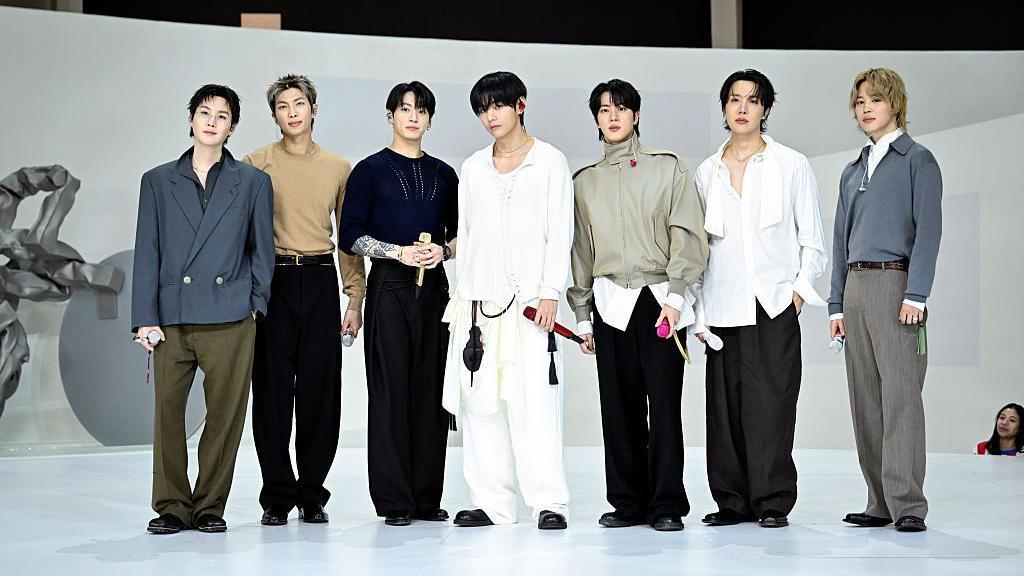 BTS posing in front of a white background 