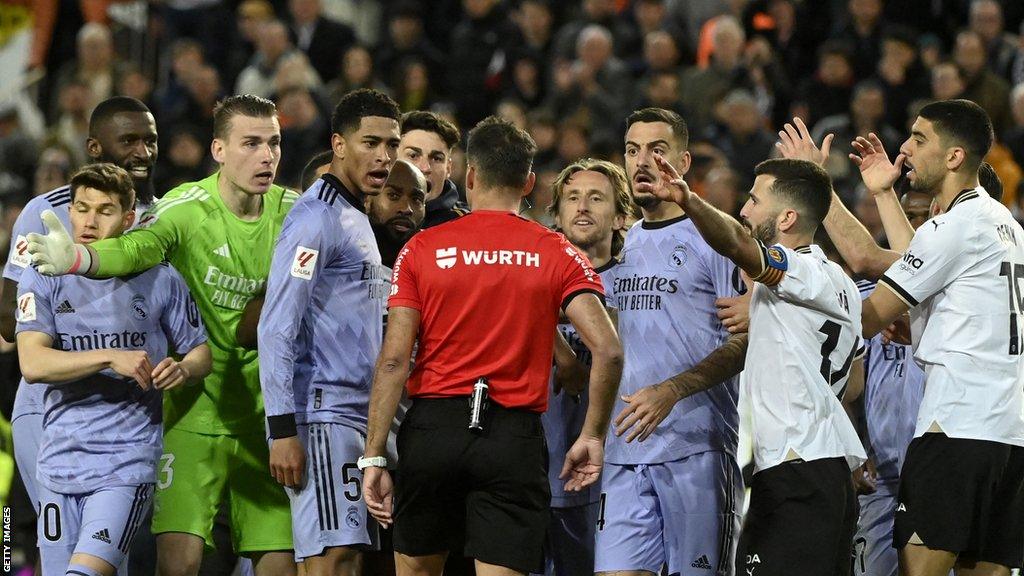 Players surround the referee