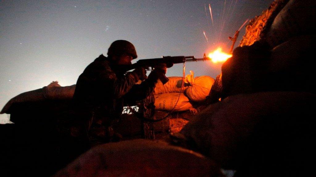 A Ukrainian soldier fires his machine gun amid sporadic clashes in the border area