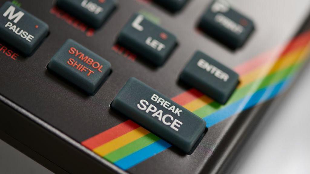 A close up of the dark grey rubber keys on the ZX Spectrum keyboard, with a rainbow stripe