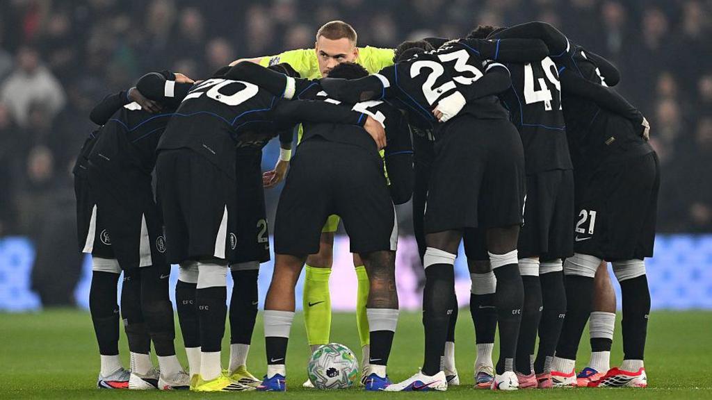 Chelsea gather in a huddle on the pitch at Villa Park