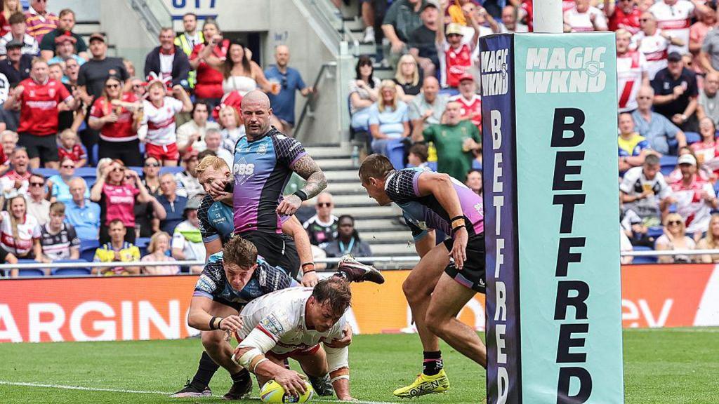 Jai Whitbread of Hull KR touches down under pressure from a Hull FC player