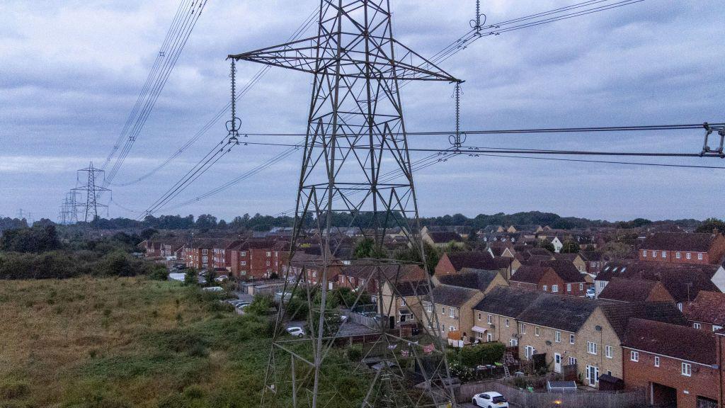 A pylon in a field near houses