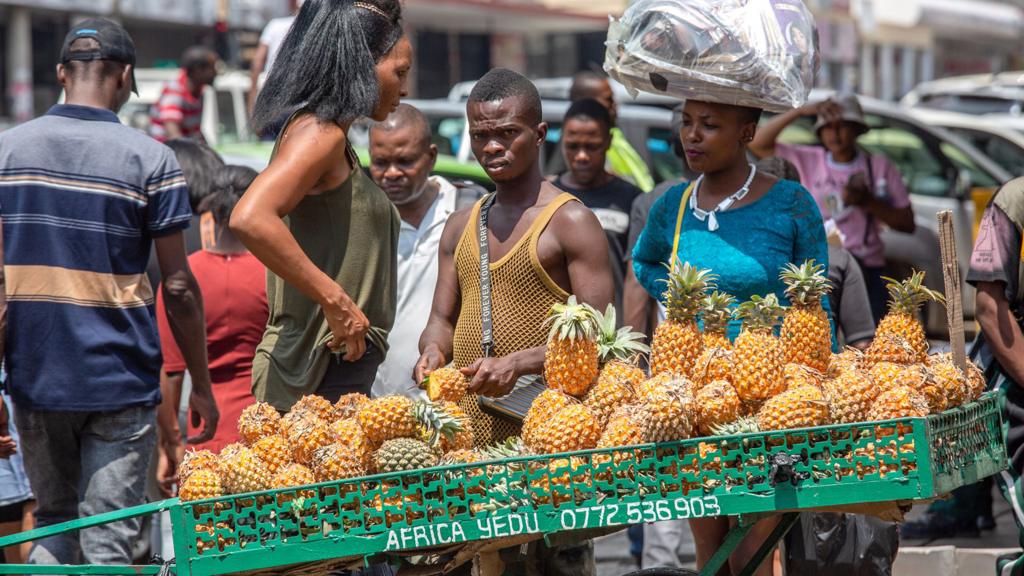 A vendor sells pineapples at a roadside stall in Harare, Zimbabwe, 20 November 2023