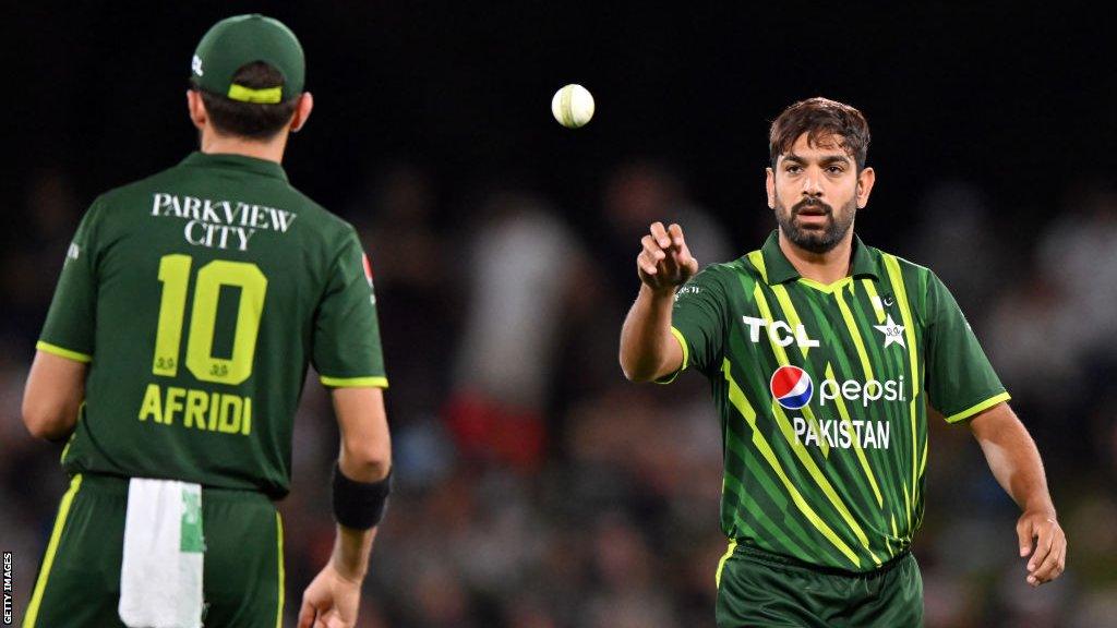 Haris Rauf (right) catching a cricket ball from Shaheen Afridi