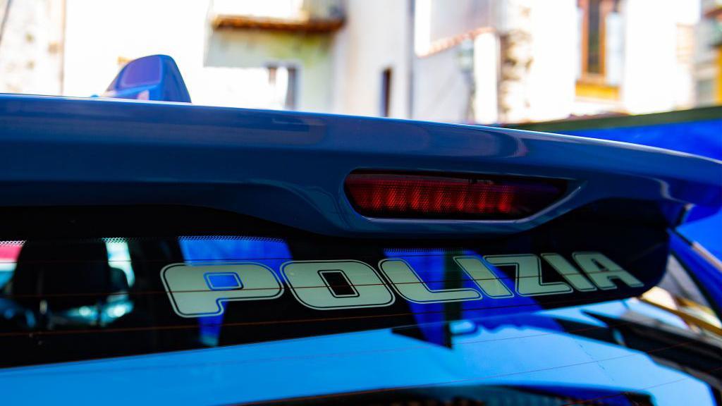 A close-up shot of the top of a police car. The Polizia branding can be seen at the top of the back windshield