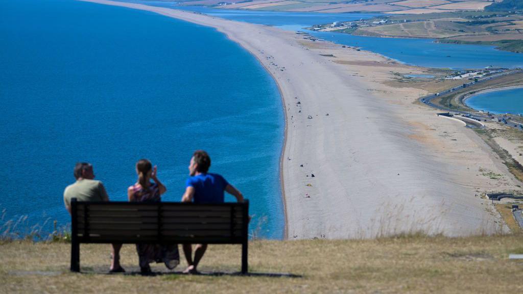 People sunbathing near Chesil Beach in Portland