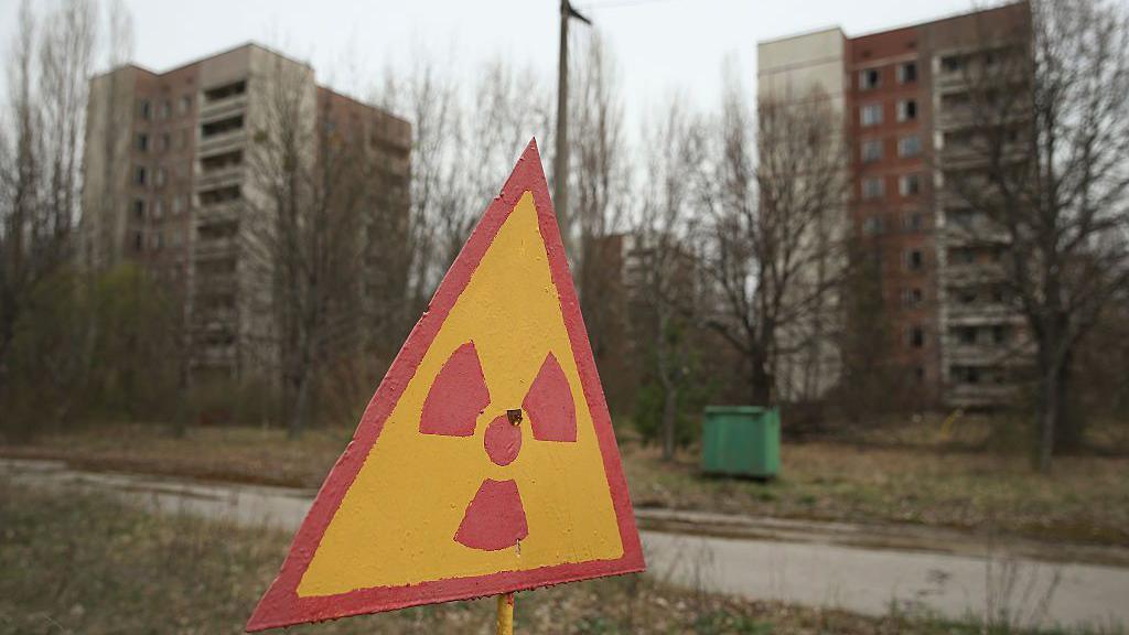 A sign warns of radiation contamination near former apartment buildings in Pripyat, Ukraine.
