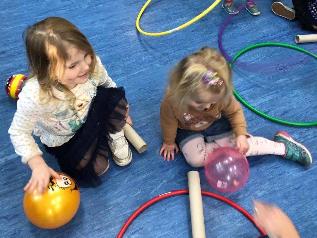 Two girls with balls, tubes and hoops