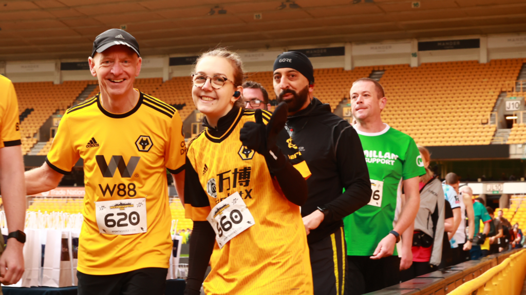 Runners in the Compton Care 10k in the Molineux stadium, with the two front runners smiling at the camera