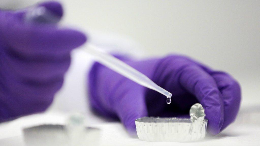 A scientist holding a pipette