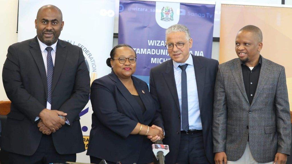 New Tanzania coach Adel Amrouche shakes hands with an official from the Tanzania Football Association.