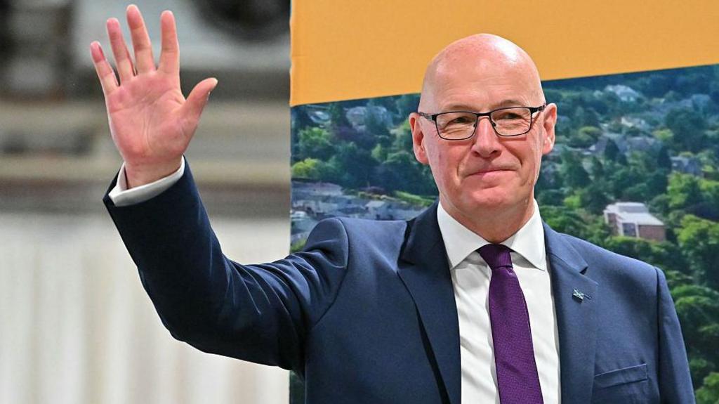 John Swinney waving
