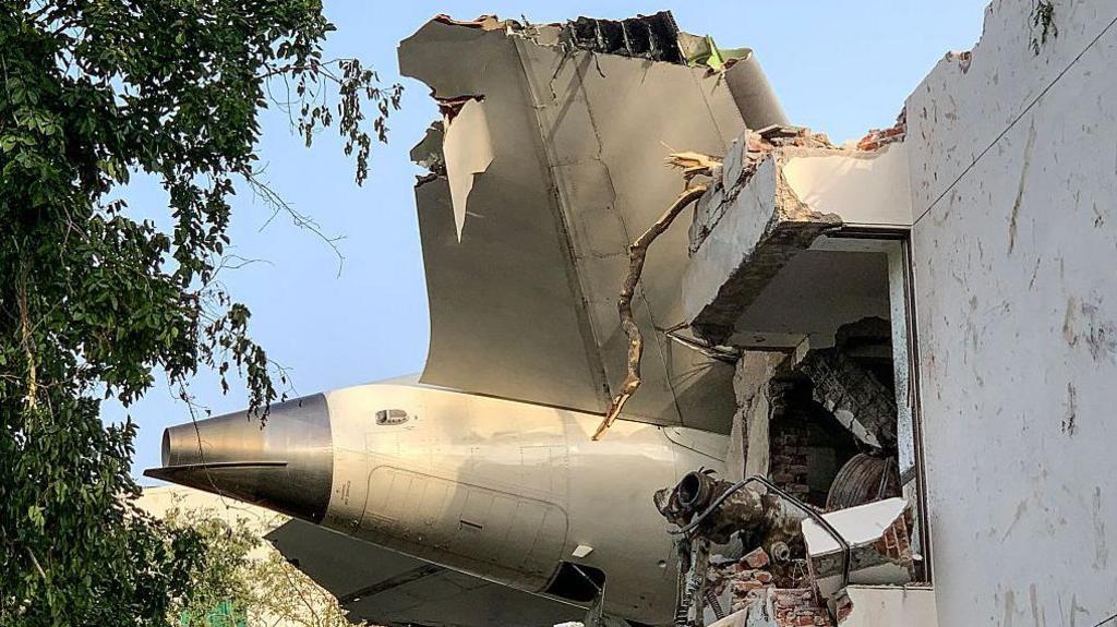 The back of Air India flight 171 is pictured at the site after it crashed in a residential area near the airport in Ahmedabad on June 12, 2025. A London-bound passenger plane crashed in the Indian city of Ahmedabad on 12 June and all 242 people on board were believed killed, with the jet smashing into buildings housing doctors and their families.