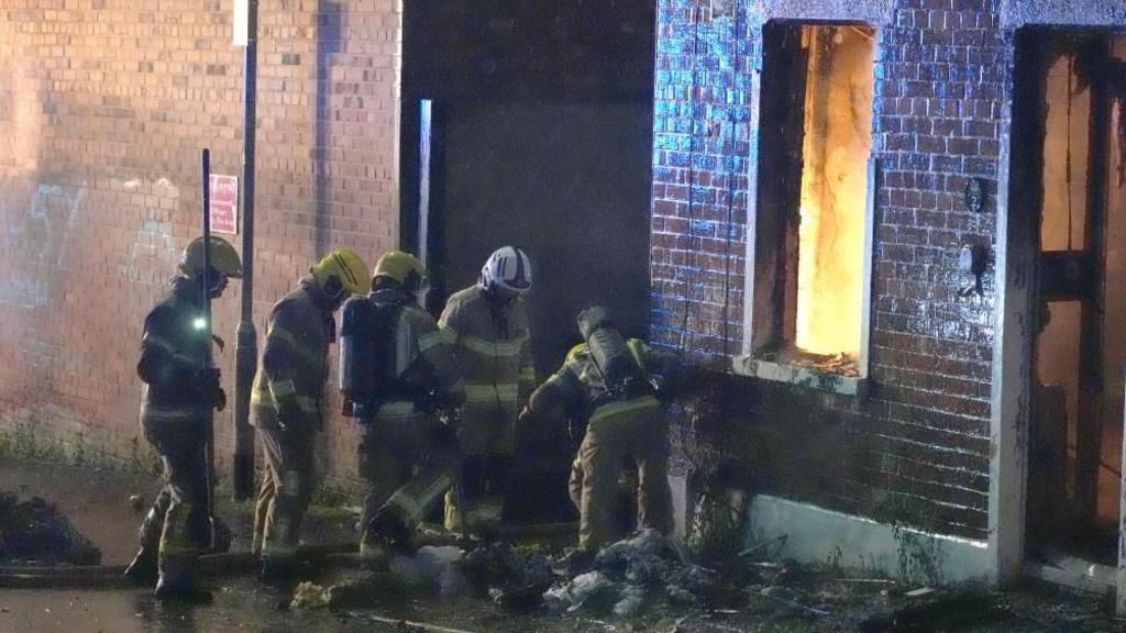 Firefighters attend a house which caught fire on Ligoniel Road, Belfast, as disorder flared during an anti-immigration demonstration organised in response to Monday night's stabbing attack in the city. 
