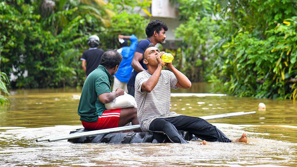 People navigate floodwaters on a makeshift raft as heavy rains from Cyclone ''Ditwah'' sweep through Colombo, Sri Lanka, on 29 November 2025.