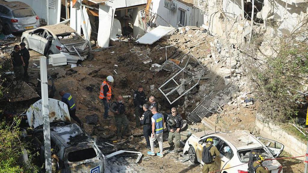 Israeli emergency service personnel gather at the site of an Iranian missile strike in Tel Aviv