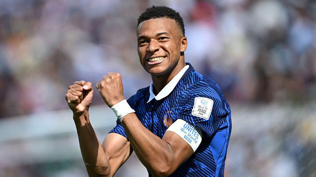 Kylian Mbappé smiling.