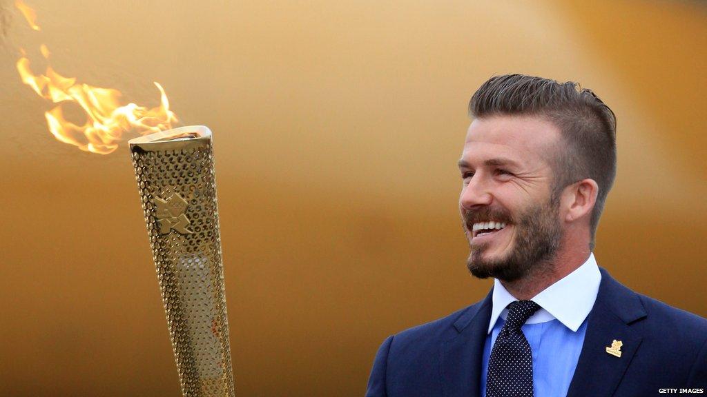 David Beckham holding the 2012 Olympic torch.