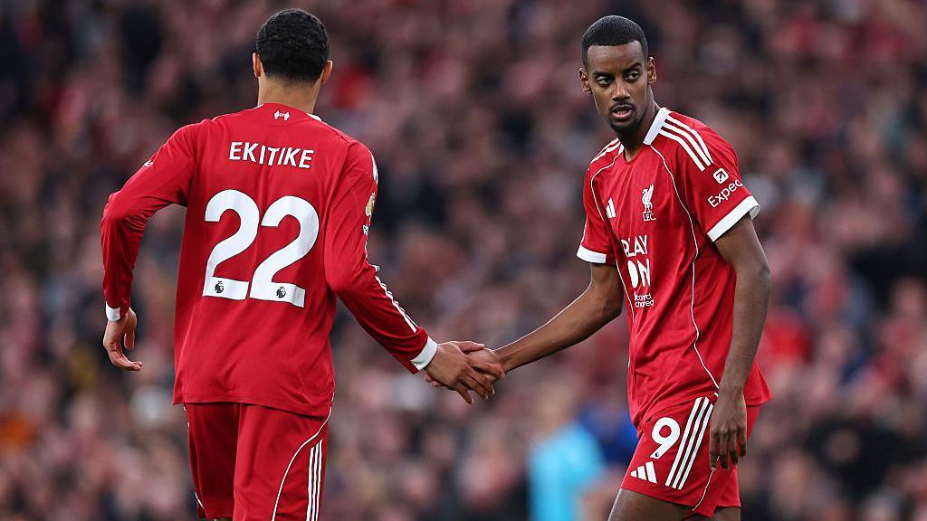 Hugo Ekitike shakes hands with Alexander Isak