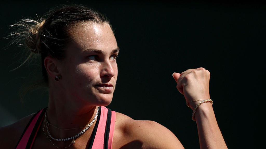 Close-up of Aryna Sabalenka who is raising her fist to celebrate winning a point.