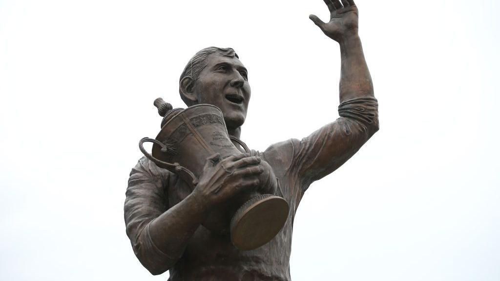 Statue shows Fred Keenor waving and holding FA Cup