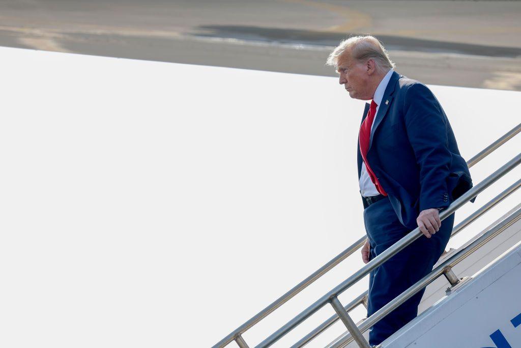 Donald Trump walks down the stairs of his private plane.