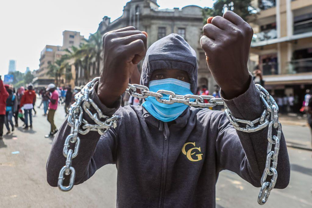  A protester with both hands tied with a chain takes part in an anti-government protest on 2 July.