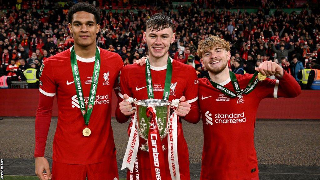 Liverpool's Conor Bradley pictured with the League Cup trophy alongside Jarell Quansah and Harvey Elliott.