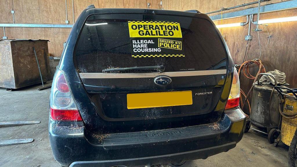 A black Subaru Forester with a sticker on the back window shield reading "Operation Galileo, illegal hare coursing, seized by police".