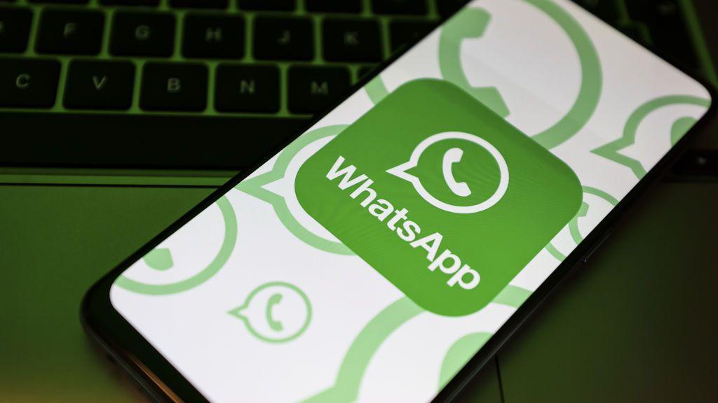 A stylised image shows the Whatsapp logo on a mobile phone screen, placed on a keyboard 