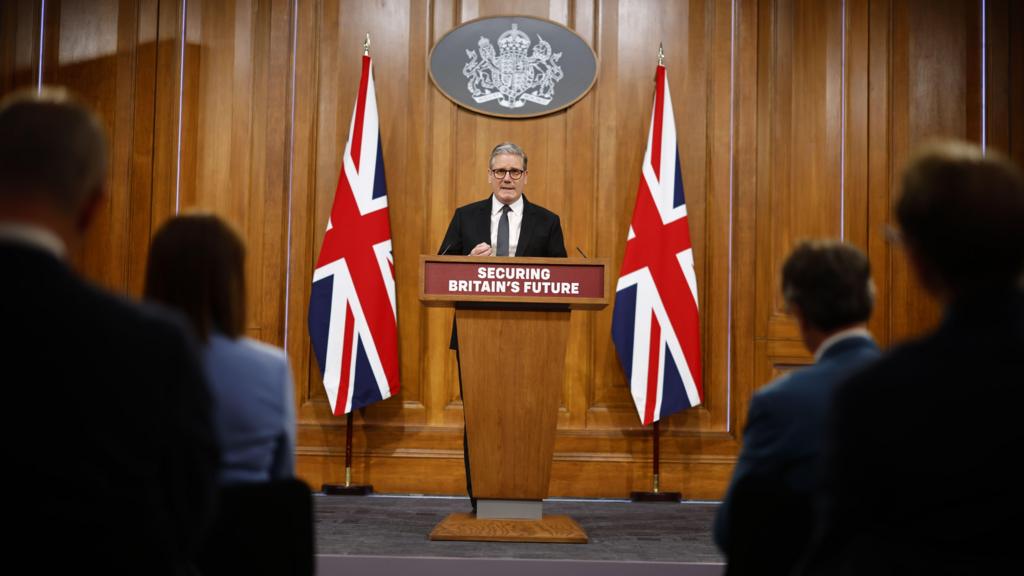 PM addresses press in front of union flags