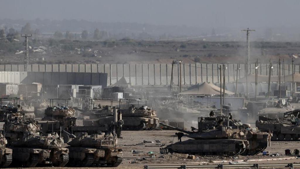 Tanks are seen on the Israeli side of the Israeli-Gaza border. Gaza is seen in the background.