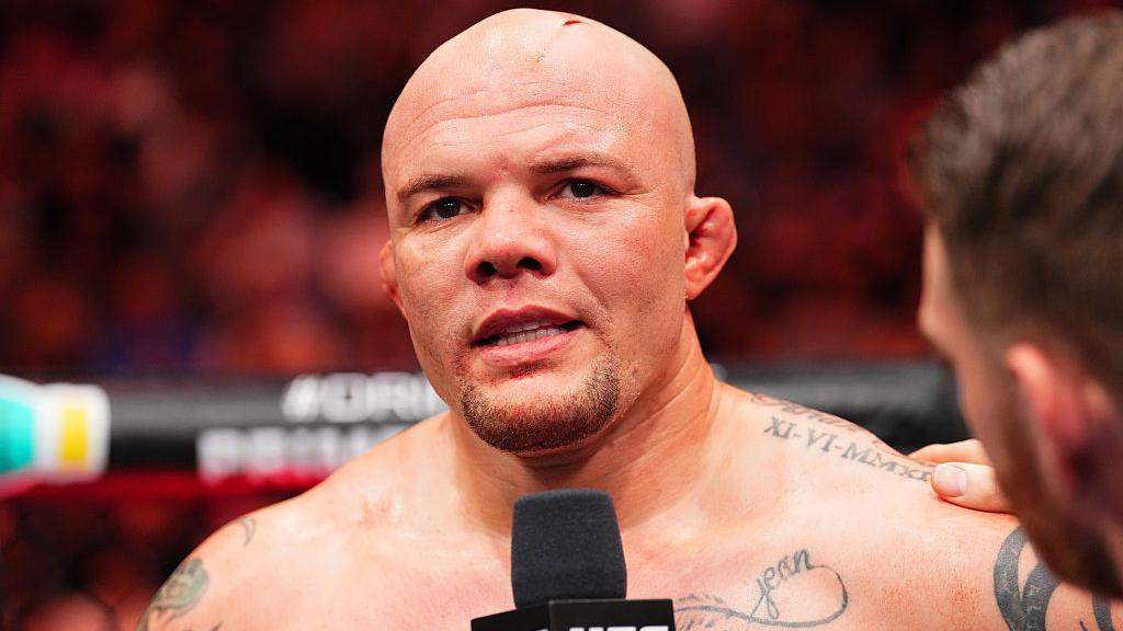 Anthony Smith speaks into a microphone