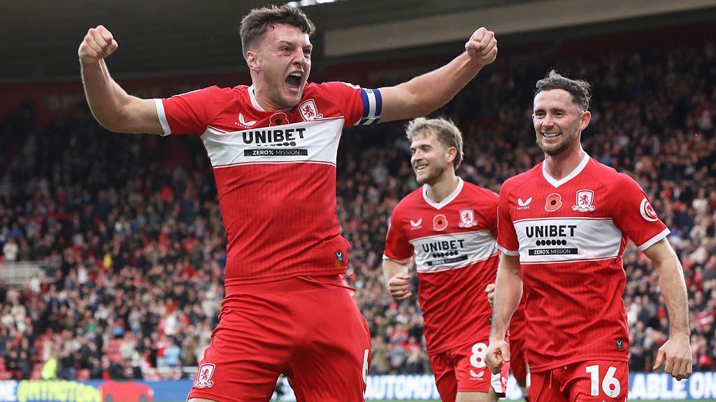 Middlesbrough captain Dael Fry has his arms outstretched in celebration after scoring the opening goal in Boro's victory over Birmingham City. Team-mates Alan Brown and Riley McGree rush to congratulate the club's skipper