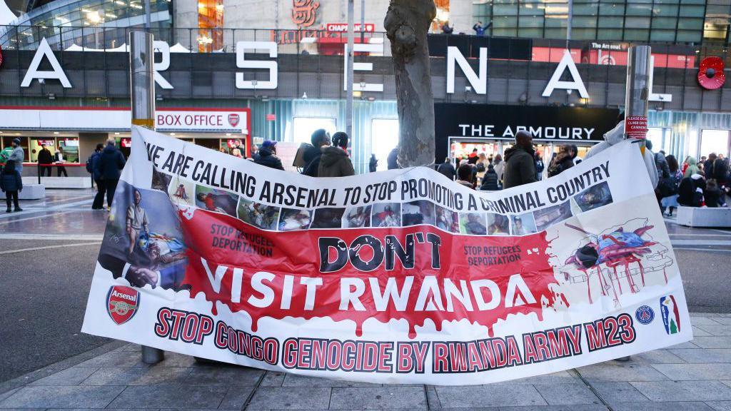 Arsenal fans protest at the club's sponsorship deal with Visit Rwanda by holding up a banner outside Emirates Stadium