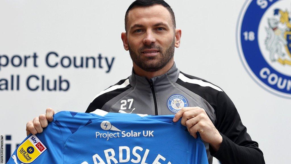 Stockport signing Phil Bardsley holds his shirt